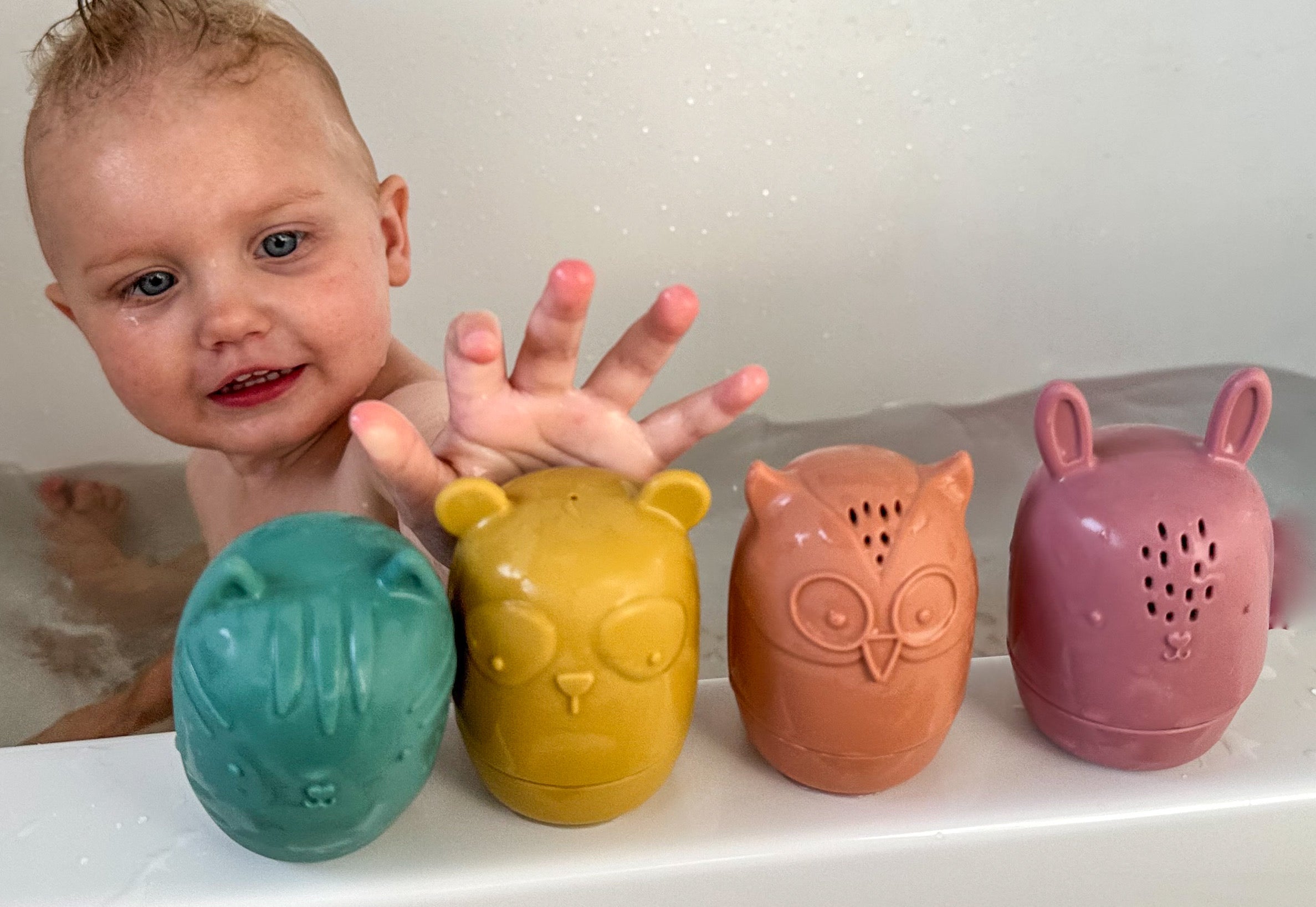 Child enjoying bath time with Bumble & Ivy Woodland Bath Toys. Easy-clean mould-resistant silicone bath toys featuring bear, owl, fox and bunny characters designed for sensory play and toddler bath time fun.